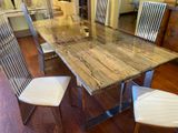 a glass dining table with a metal base and white chairs