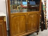 une vitrine située dans un coin de la pièce, à côté d'une commode