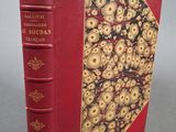 un vieux livre à la couverture rouge ornée de motifs dorés
