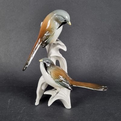 deux figurines d'oiseaux assis l'un sur l'autre