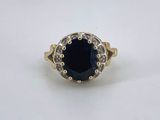 a gold ring with a blue stone surrounded by white diamonds
