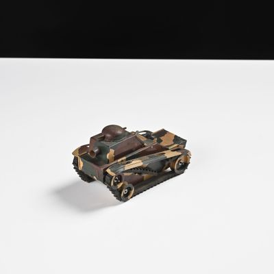 un petit char de jouet posé sur une surface blanche