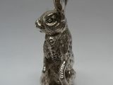 une figurine de lapin en argent assise sur ses pattes arrière