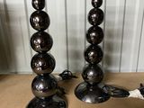pair of chrome ball lamps on a table in a room