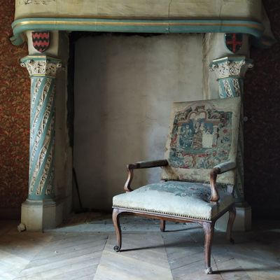 un fauteuil placé devant une cheminée dans une pièce