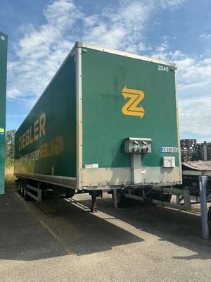 un semi-remorque vert garé sur un parking