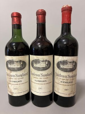 three bottles of red wine are lined up on a table