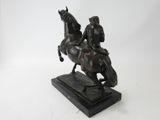 bronze statue of a man riding a horse on a black base