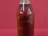 a bottle of liquid sitting on a red surface