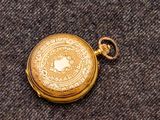 une montre de poche en or posée sur une table