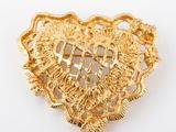 une image représentant une broche en forme de cœur ornée d'une croix