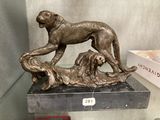une statue en bronze représentant un chien et un chien posé sur une table