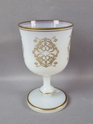 une tasse blanche et dorée ornée d'un motif doré