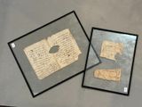 deux feuilles de papier encadrées et une feuille de papier posée sur une table