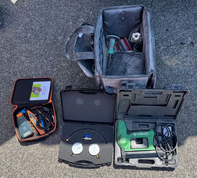 a suitcase that is sitting on the ground with electronics in it