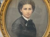 an old picture of a woman in a black dress in a gold frame