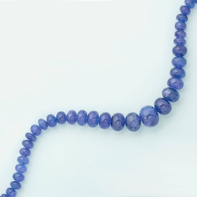 a picture of a strand of blue beads on a white surface