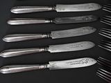 a lot of forks and knives that are on a table