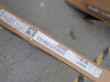 someone is holding a box with a barcode on it in a warehouse
