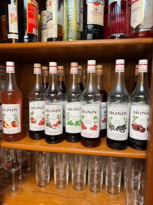 de nombreuses bouteilles et verres posés sur une étagère dans un bar