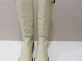 pair of white boots on a white surface with a wall in the background