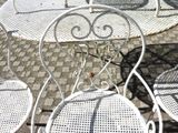 four chairs and a table on the sidewalk
