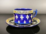 a blue cup and saucer on a black table