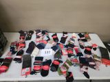 de nombreuses paires de chaussettes posées sur une table, avec leurs étiquettes de prix