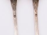 pair of silver spoons sitting on top of a white surface
