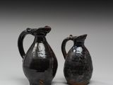 une paire de vases noirs posés l'un sur l'autre sur une table