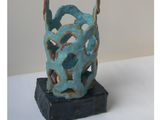 a blue vase with a handle on top of a table