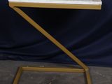 une table d'appoint blanche et dorée avec un plateau en marbre