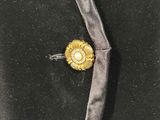 a close up of a black jacket with a gold flower on it