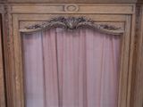 a wooden frame with a pink curtain behind it