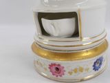 a white and gold tea pot with a cup on top of it