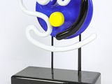 a blue and white sculpture with a yellow ball on it