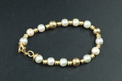 un gros plan d'un bracelet orné de perles sur un fond noir