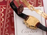 a gold watch and a red book on a table