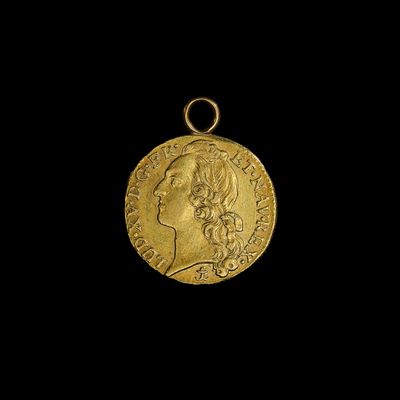 gros plan d'une pièce d'or portant un visage de femme