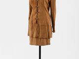 une robe marron posée sur un mannequin, avec un col blanc