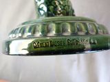 a close up of a green vase with a bird on it
