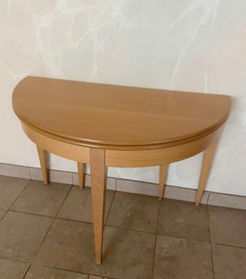 a wooden table with a curved top on a tiled floor