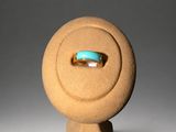 an image of a ring on a stand with a turquoise stone in the middle
