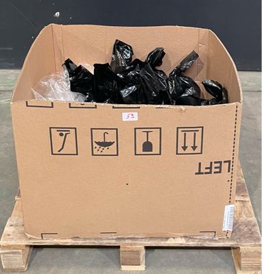un carton rempli de sacs poubelles noirs posé sur une palette