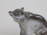a figurine of a cat that is sitting on a table