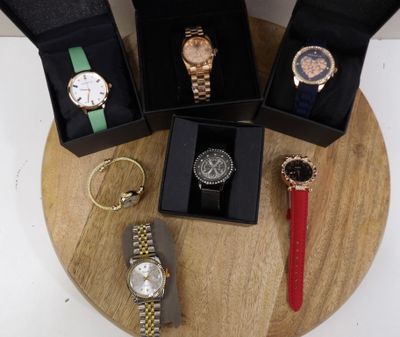 four different watches in a box on a table