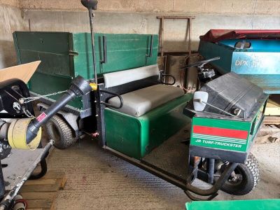 un petit chariot vert avec un siège vert dans un garage