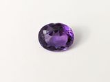 gros plan d'une pierre précieuse violette sur une surface blanche