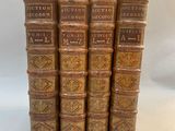 un ensemble de cinq livres anciens reliés en cuir sur fond blanc
