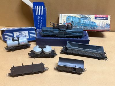 beaucoup de petits trains posés sur une table à côté d'une boîte
